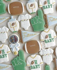 decorated cookies are arranged in the shape of footballs and tee - shirts for baby showers