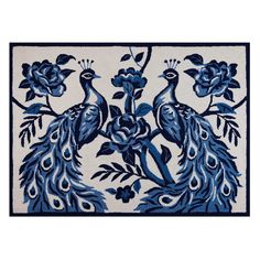 a blue and white rug with two peacocks on it