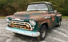 an old rusted truck parked in a parking lot