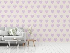 a living room with a couch, table and wallpaper that has hearts on it