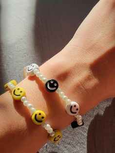 Brighten up your day with these cheerful handmade smiley face beaded bracelets! Featuring cute smiley face charms in your choice of black/white or yellow/white color combinations, these bracelets are made with faux pearl beads and elastic cord for a comfortable, stretchable fit. Whether you're looking for a playful accessory or a thoughtful gift, these smiley face bracelets are sure to add a pop of positivity to any outfit. Affordable Cute Smiley Face Beaded Bracelets, Cheap Trendy Stretch Bracelet With Smiley Face, Cheap White Smiley Face Bracelets, White Color Combinations, Cute Smiley Face, Customizable Jewelry, Clay Bracelet, Happy Face, Clay Beads