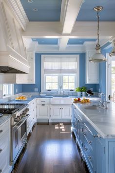 a kitchen with blue walls and white cabinetry, wood flooring and stainless steel appliances