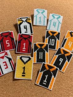 six cross stitch badges with different colors and designs on them, including one man's shirt