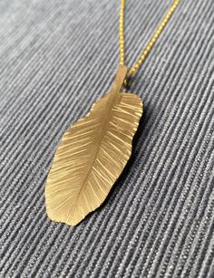 Gold banana plant leaf necklace with a delicate chain. The pendant measures 1”x 2” (2,5 x 5 cm) #houseplant #tropicalleaf #necklace Nature-inspired Leaf-shaped Brass Jewelry, Leaf-shaped Yellow Gold Brass Jewelry, Nature-inspired Gold Leaf Necklace, Gold Leaf Shaped Brass Jewelry, Gold Leaf-shaped Nature-inspired Necklace, Gold Leaf-shaped Brass Jewelry, Gold Leaf Nature-inspired Jewelry, Nature-inspired Gold Leaf-shaped Jewelry, Gold Nature-inspired Necklace With Large Pendant