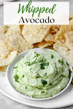 a white plate topped with guacamole and chips