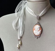 Peach Cameo Necklace!Perfect for any occasion!!A soft peach cameo set in an antique silver pendant and attached to a light cream organza ribbon....I have added 2 light cream teardrop pearls to the end of each tie....The perfect gift for that very special lady or teen.....Please select if you would like this item gift wrapped.....I will also include a quality card with your special message.....Thank you for taking time to browse my shop “Veronica Rose Designs” Luxury Cameo Necklace For Formal Events, Elegant Cameo Necklace For Formal Occasions, Elegant Cameo Jewelry For Wedding, Vintage Cameo Jewelry For Wedding, Victorian Cameo White Jewelry, Elegant Cameo Necklaces For Wedding, Elegant Cameo Necklace For Wedding, Victorian White Cameo Jewelry, Elegant White Cameo Necklace