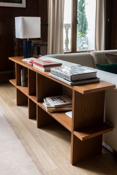 a living room with a couch, coffee table and books on top of each shelf