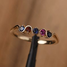 It is a multi stone silver band,delicate stacking ring . The main stone is 2.5 mm round cut. Lab Sapphire / Garnet / Lab Ruby The basic metal is sterling silver plated with rhodium. To change the metal to a solid gold (white/yellow /rose) or platinum is also available, please ask for a quotation if you want. You can also go to my shop Home for more elegant rings: https://www.etsy.com/shop/godjewelry?ref=hdr_shop_menu More rings: https://www.etsy.com/shop/godjewelry?ref=l2-shop-header-avatar Cust 14k Gold Multi-stone Stackable Rings, 14k Gold Multi-stone Stackable Rings For Anniversary, Multi-stone Stackable Rings For Promise, Multi-stone Stackable Promise Rings, Rose Gold Multi-stone Birthstone Ring, Anniversary Multi-stone Birthstone Ring In Rose Gold, Rose Gold Multi-stone Birthstone Ring For Anniversary, Anniversary Rose Gold Multi-stone Birthstone Ring, Stackable Rose Gold Birthstone Ring With Round Band