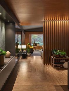 a long hallway with wood paneling and plants on the side tables in front of it