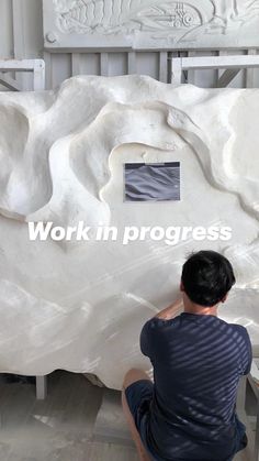 a man working on a large white sculpture