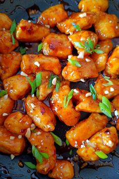 chicken with sesame seeds and sauce in a frying pan