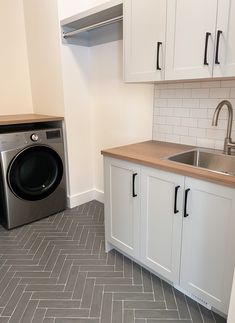 a washer and dryer sitting in a kitchen next to each other on the floor