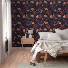 a bed sitting in a bedroom next to a wall with flowers on it's side