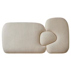 two pillows sitting next to each other on top of a white surface with one pillow in the middle