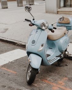 a blue scooter is parked on the side of the road