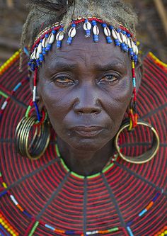 a woman from the african tribe with large hoop earrings and headdress on her face