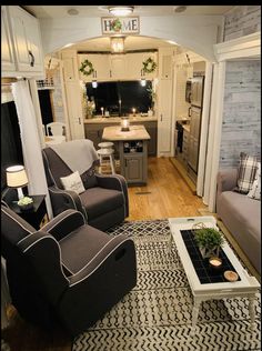 a living room filled with furniture next to a kitchen