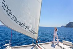 a woman standing on the bow of a sailboat