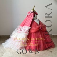 a pink and white dress on display with the name aurora written in gold above it