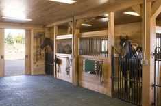 the inside of a stable with horses in stalls