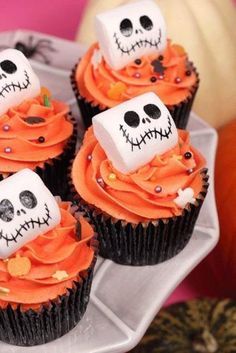 cupcakes decorated with orange frosting and skulls