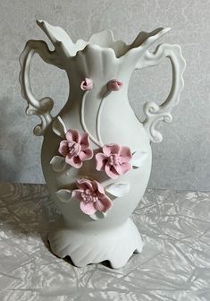 a white vase with pink flowers on it