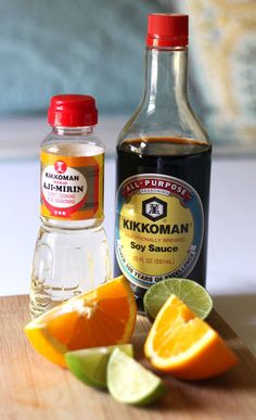 an orange, lime and ginger syrup sit on a cutting board next to some cut up fruit