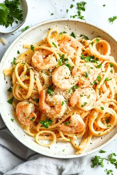 pasta with shrimp and parsley in a white bowl