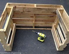 a wooden box with tools in it sitting on the ground next to some wood pallets