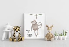 two stuffed animals sitting next to each other near a poster with the words stay silly on it