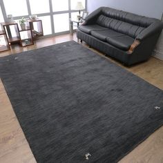 a living room with a black leather couch and rug