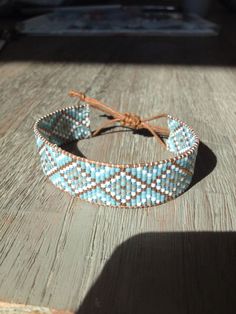 a blue and white bracelet sitting on top of a wooden table