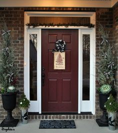 the front door is decorated for christmas with potted plants