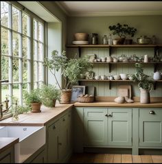 a kitchen filled with lots of green cupboards