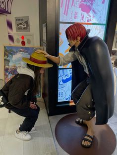 two figurines are standing next to each other in front of a display window