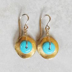 "Gold Disc Earrings with Turquoise - Turquoise and Gold Earrings - Gold Drop Earrings - Gold and Turquoise Earrings These gold disc and turquoise earrings feature genuine turquoise rondelles that sit upon small, wavy \"cornflake\" beads that are plated in 24 kt. gold. They dangle from 14 kt. gold-filled French earwires. These gold drop earrings possess an organic appeal, yet at the same time, are absolutely elegant! The wavy \"cornflake\" disc used in these unique earrings are one of Roca Jewelr Handmade Turquoise Brass Earrings, Turquoise Dangle Earrings In Brass, Turquoise Dangle Brass Earrings, Turquoise Brass Earrings As Gift, Turquoise Brass Earrings For Gift, Gift Turquoise Brass Earrings, Turquoise Brass Earrings, Artisan Turquoise Nickel-free Earrings, Turquoise Brass Jewelry With Ear Wire