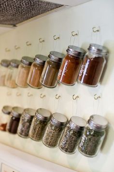 spice jars are hanging on the wall in this kitchen storage and organization idea for small spaces