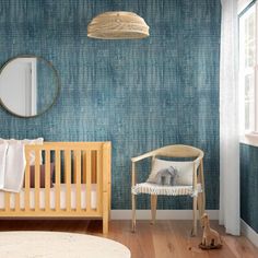 a baby's room with blue wallpaper and wooden furniture