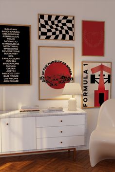 a white chair sitting next to a table in a room with pictures on the wall