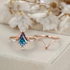 two rings with blue and white diamonds on them, one in the shape of an arrow