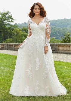 a woman in a wedding dress standing on grass