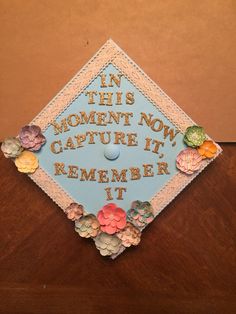 a blue graduation cap that says in this moment now capture it, remember it