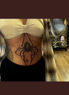 a woman with a spider tattoo on her stomach