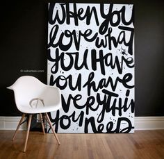 a white chair sitting in front of a black and white wall with writing on it