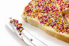 a piece of cake with sprinkles on it next to a knife and fork