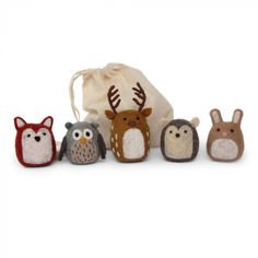 an assortment of small stuffed animals sitting next to each other in front of a bag