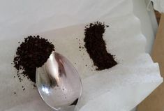 two spoons filled with dirt sitting on top of paper