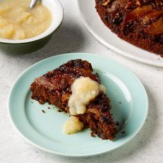 a piece of cake sitting on top of a blue plate next to a bowl of pudding