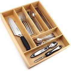 a wooden tray with utensils and knives in it