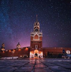 the night sky is filled with stars above an old brick building and cobblestone walkway